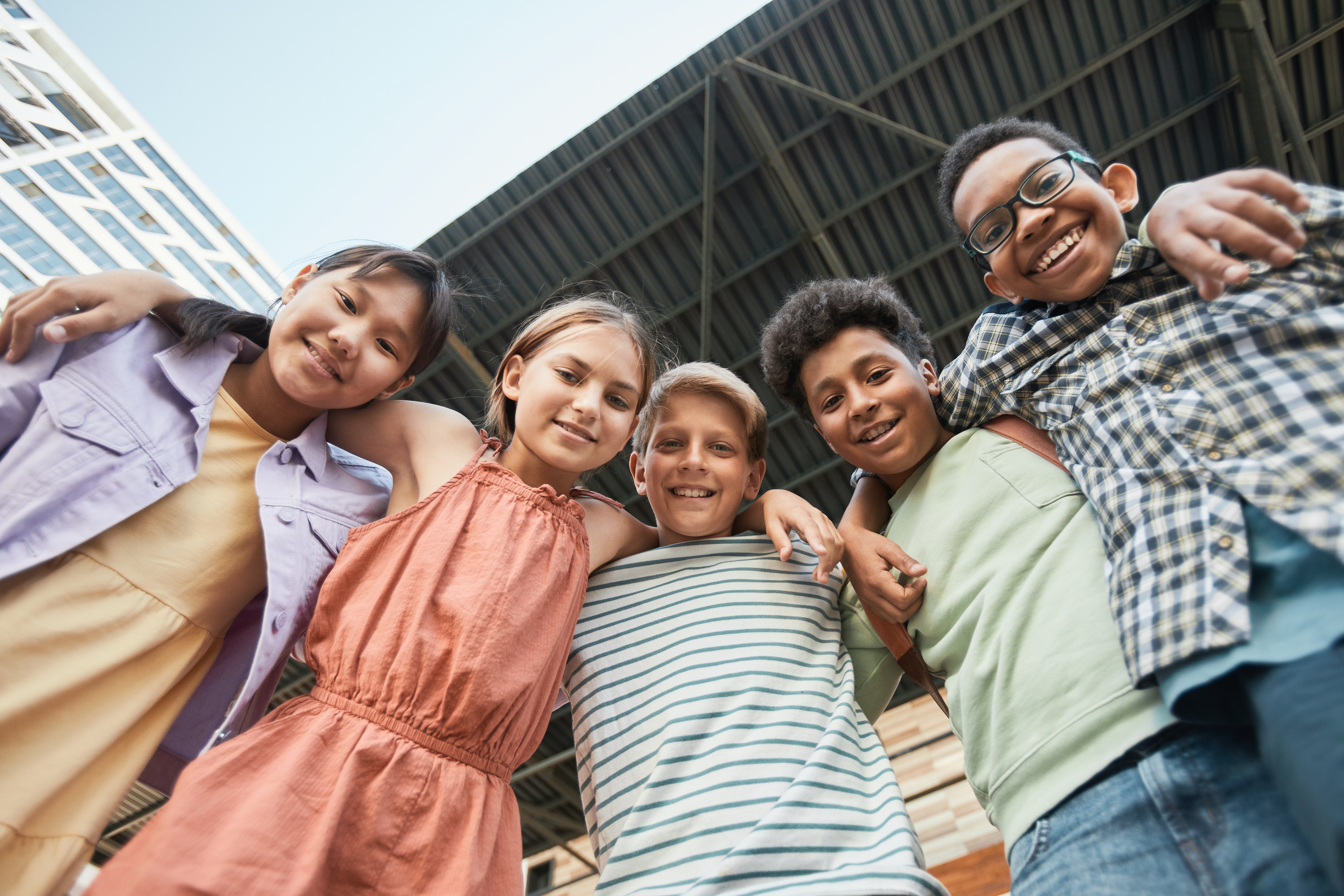 Students smiling at the camera with arms around each other