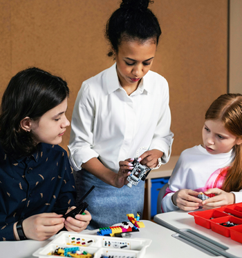 Teacher working with two students using manipulatives.