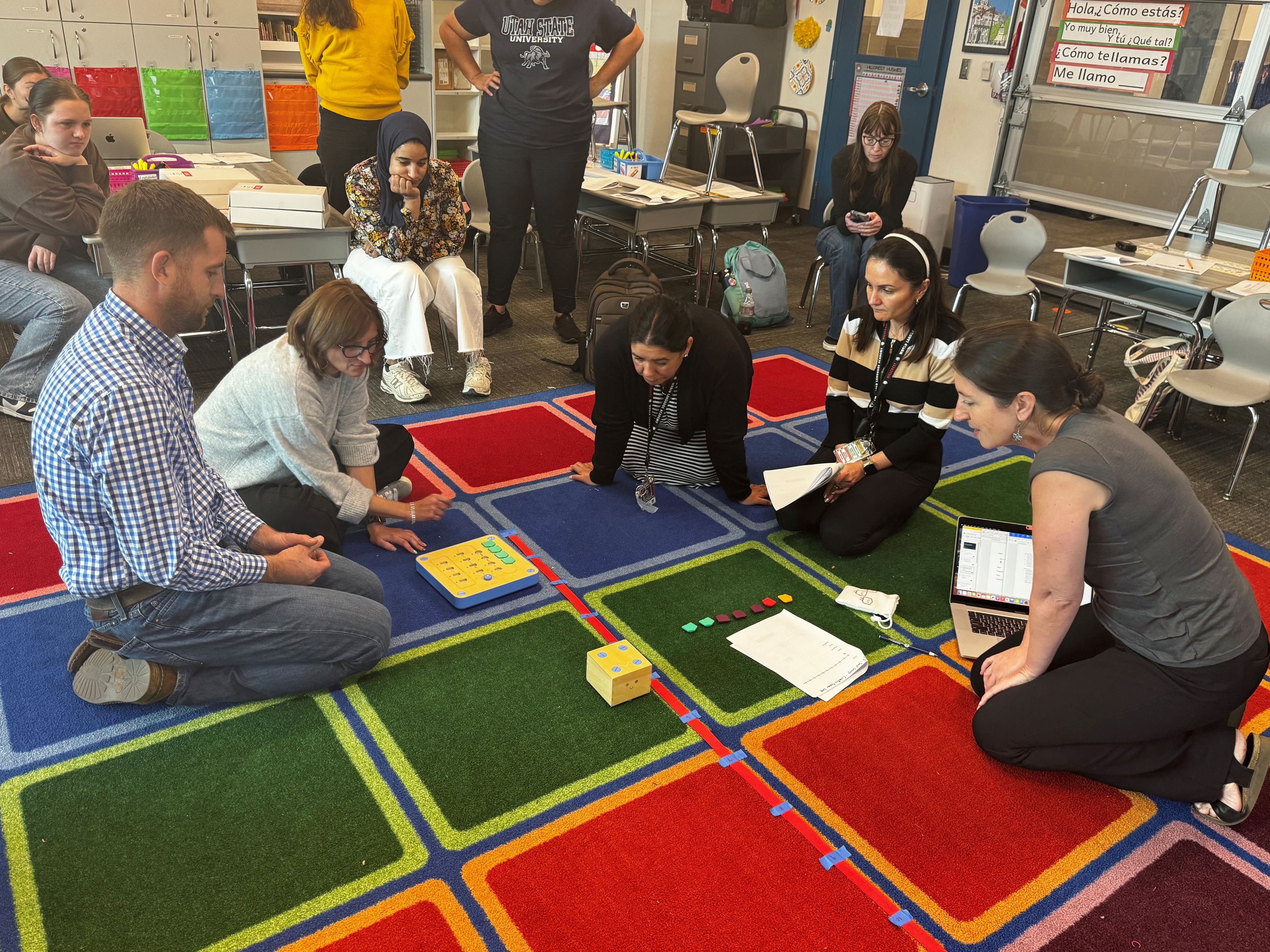 Group of educators in a classroom sitting in a circle on a rug and using math manipulatives.